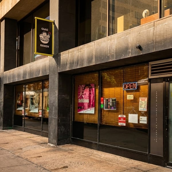 Exterior of Dishii Ramen restaurant with large windows, an "OPEN" sign, and a black and yellow sign.